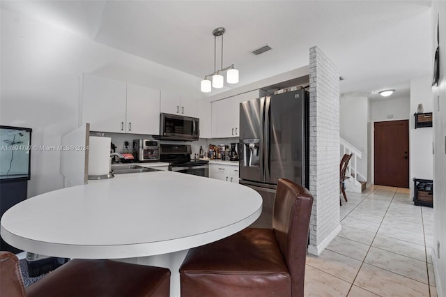 kitchen with sink, stainless steel appliances, kitchen peninsula, pendant lighting, and white cabinets