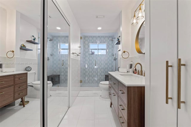 bathroom with tile walls, toilet, a stall shower, vanity, and tile patterned floors