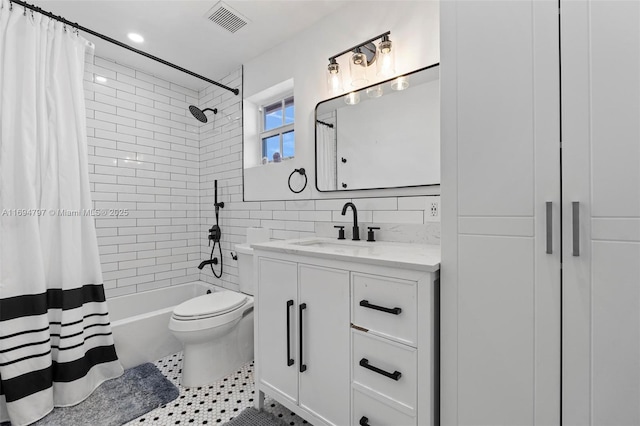 bathroom with tile patterned floors, toilet, vanity, a shower with shower door, and tile walls