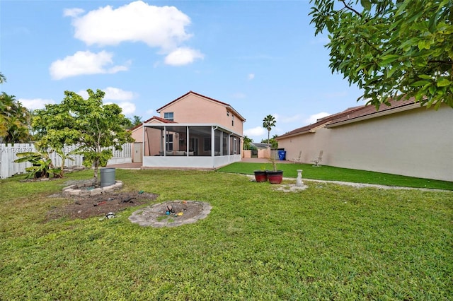 back of house with a sunroom, a fenced backyard, and a yard