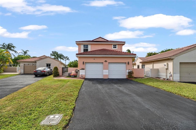 mediterranean / spanish home with stucco siding, a gate, a garage, a tiled roof, and a front lawn