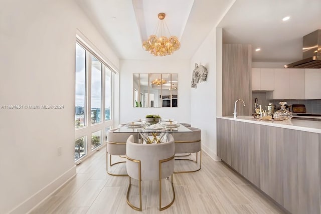 dining room with plenty of natural light, light wood-type flooring, and an inviting chandelier