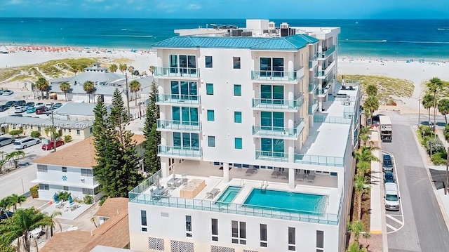 birds eye view of property featuring a water view and a beach view