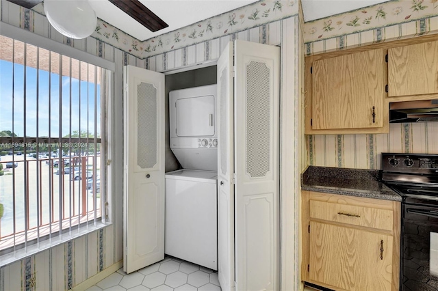 washroom featuring light tile patterned flooring and stacked washer / drying machine