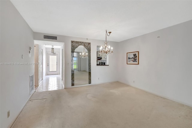 unfurnished room with a chandelier and carpet floors