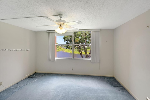 empty room with ceiling fan, carpet floors, and a textured ceiling