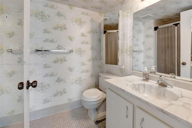 bathroom with toilet, vanity, tile patterned floors, and an enclosed shower