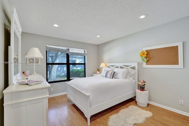 bedroom featuring a textured ceiling and light hardwood / wood-style floors