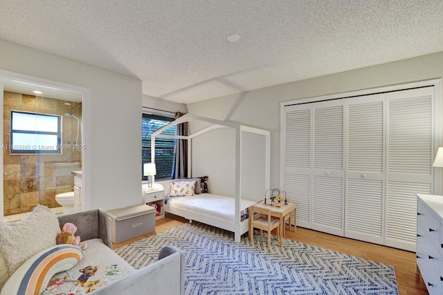 bedroom featuring a textured ceiling and light hardwood / wood-style flooring