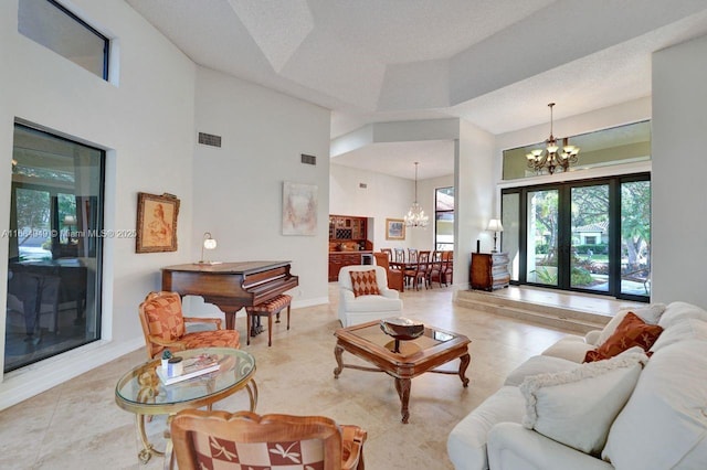 living room featuring a towering ceiling, a raised ceiling, and a notable chandelier