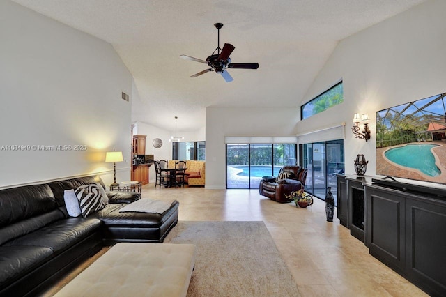 living room with ceiling fan, high vaulted ceiling, and a textured ceiling