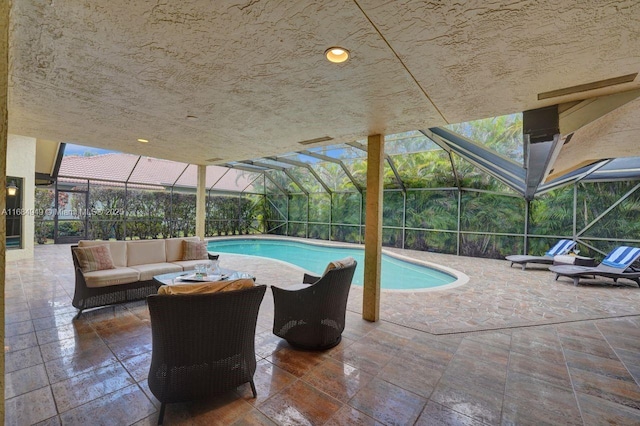 view of pool featuring outdoor lounge area, a patio, and a lanai