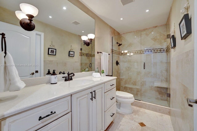 bathroom with vanity, a shower with shower door, tile walls, and toilet