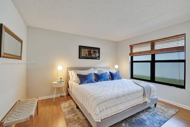 bedroom featuring a textured ceiling and hardwood / wood-style flooring