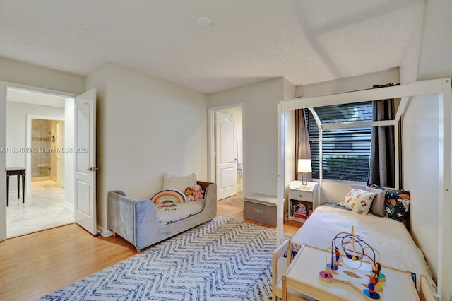 bedroom with light wood-type flooring and a textured ceiling