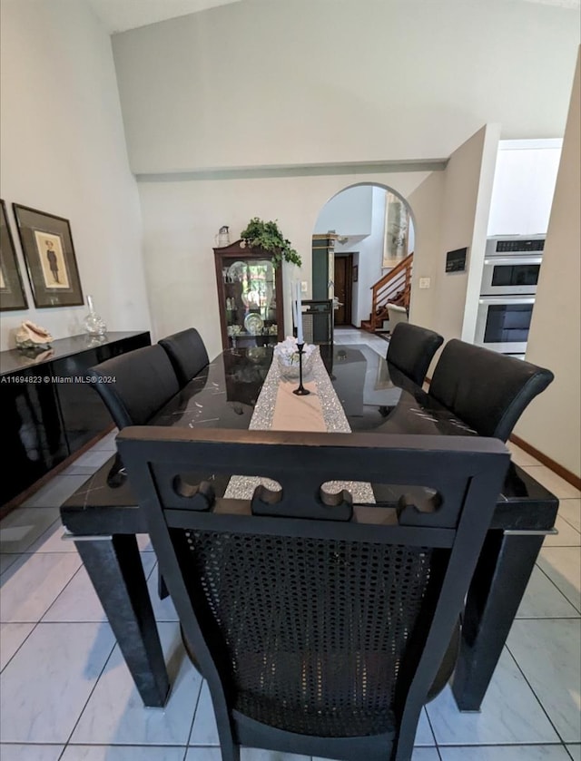 tiled dining space featuring vaulted ceiling