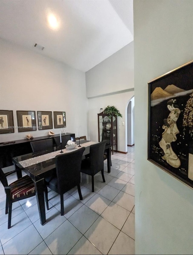 tiled dining space with high vaulted ceiling