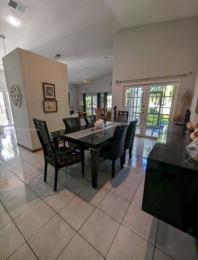 tiled dining area with french doors, a textured ceiling, ceiling fan, and lofted ceiling