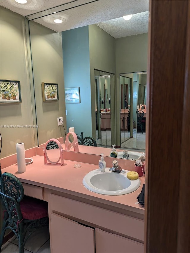 bathroom featuring tile patterned flooring, a textured ceiling, and vanity