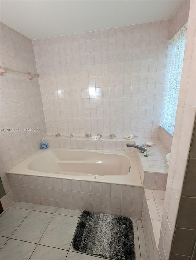 bathroom with tile patterned flooring, tile walls, and tiled bath