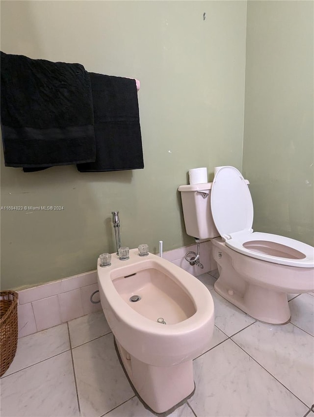 bathroom featuring tile patterned floors, toilet, and a bidet