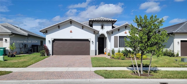 mediterranean / spanish house with a front yard and a garage