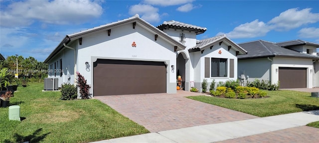 mediterranean / spanish home featuring a front yard and a garage