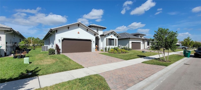 mediterranean / spanish-style house with central AC unit, a front yard, and a garage