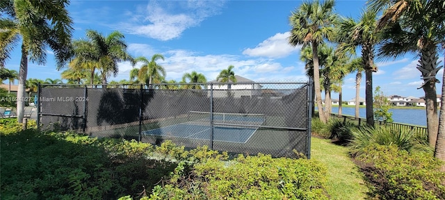 view of tennis court featuring a water view