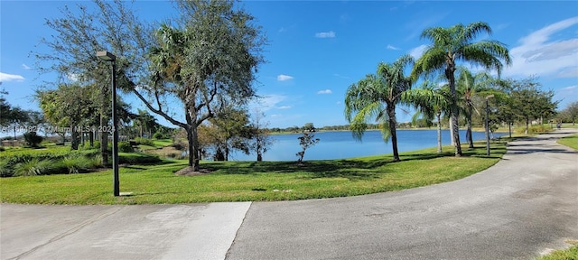 view of community with a lawn and a water view