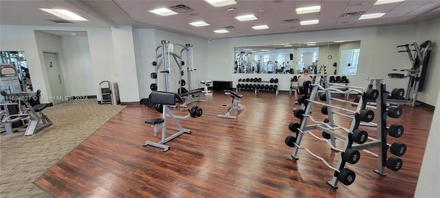 gym featuring a paneled ceiling and hardwood / wood-style floors