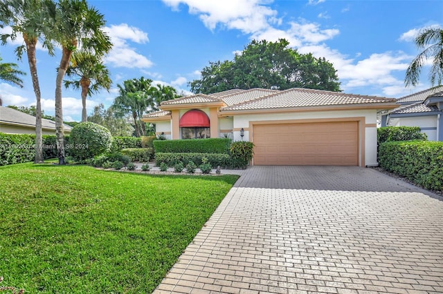 mediterranean / spanish-style house featuring a front lawn and a garage