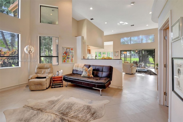 living room with a towering ceiling and light tile patterned floors