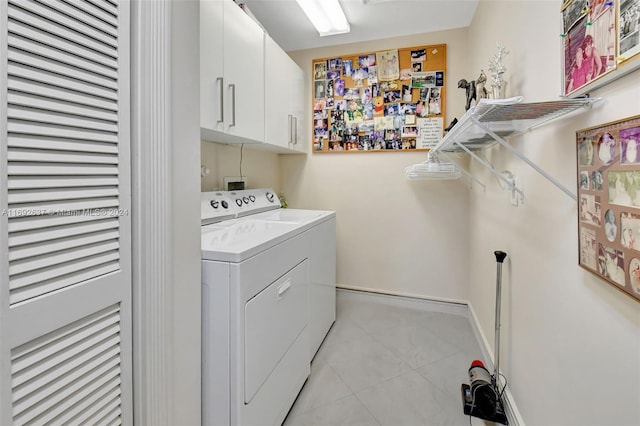 washroom with cabinets and washing machine and clothes dryer