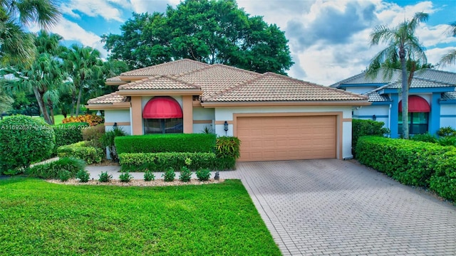 mediterranean / spanish-style house featuring a front yard and a garage