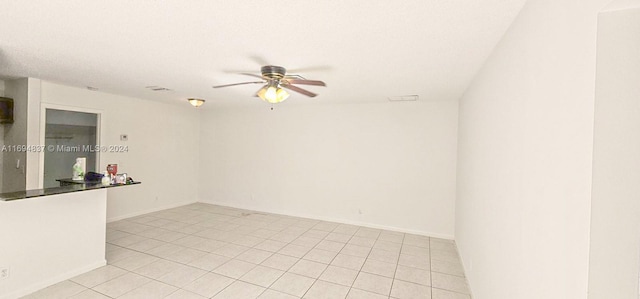 spare room with ceiling fan, light tile patterned floors, and a textured ceiling