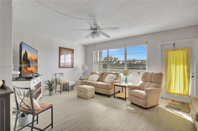 living room featuring a textured ceiling, hardwood / wood-style flooring, and ceiling fan