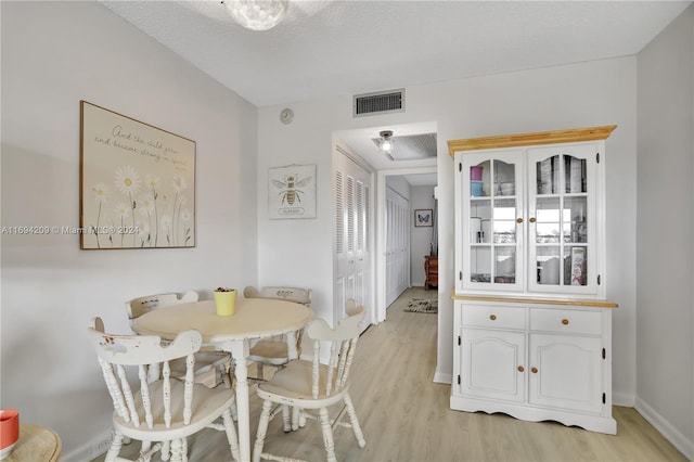 4107 E Cambridge E Unit 4107, Deerfield Beach, FL 33442 - dining area featuring light wood-type flooring, baseboards, and a textured ceiling