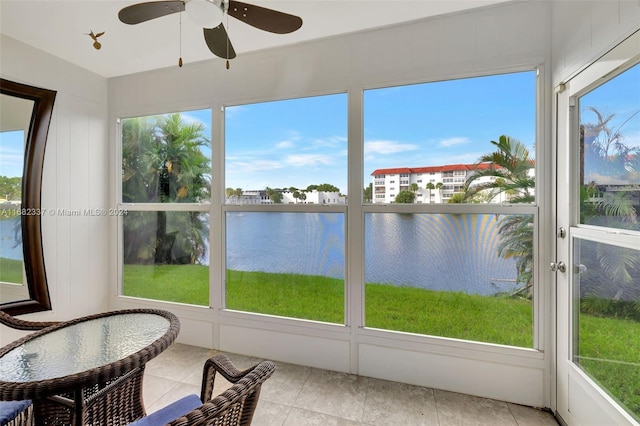 sunroom / solarium with a water view and ceiling fan