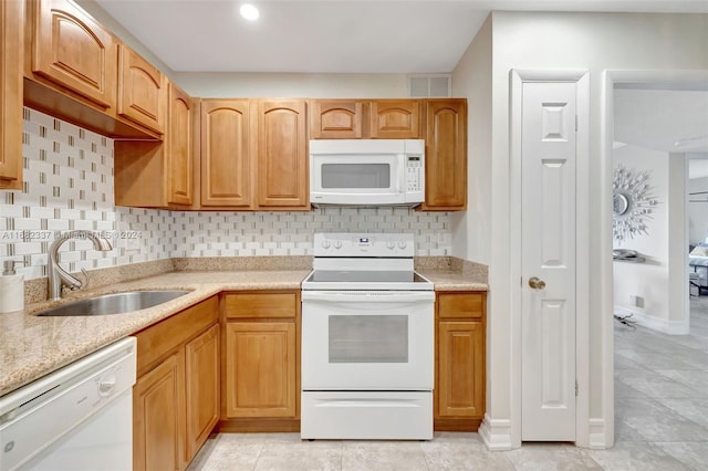 kitchen featuring decorative backsplash, light tile patterned floors, white appliances, and sink