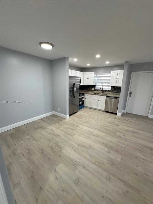 kitchen featuring white cabinetry, sink, stainless steel appliances, and light hardwood / wood-style floors