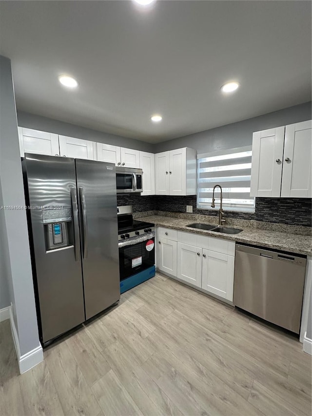 kitchen with sink, white cabinets, and stainless steel appliances