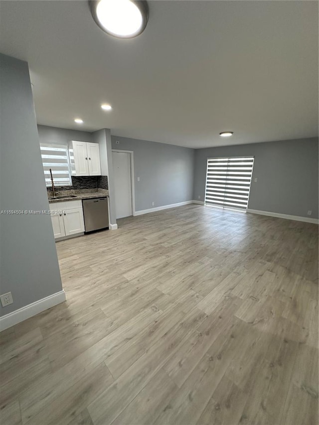 unfurnished living room featuring light hardwood / wood-style floors and sink