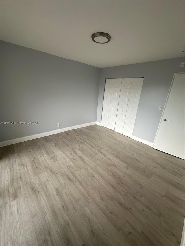 unfurnished bedroom featuring light hardwood / wood-style floors and a closet