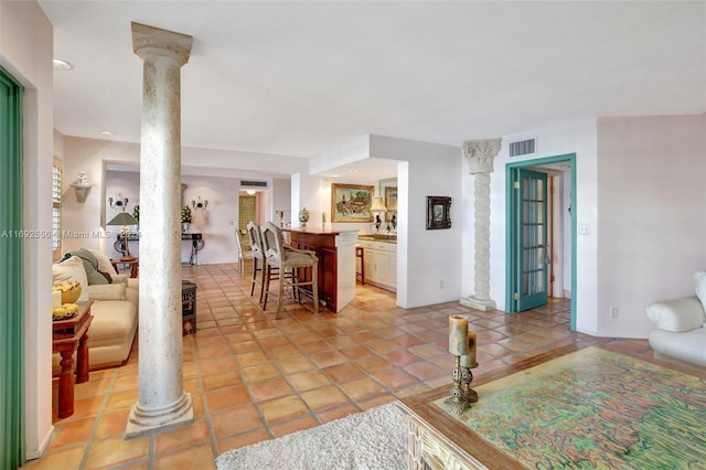 living room with ornate columns and light tile patterned floors