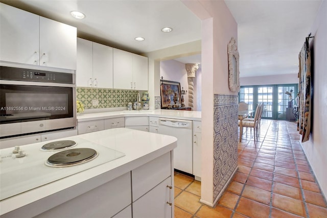 kitchen with backsplash, white cabinetry, french doors, and white appliances