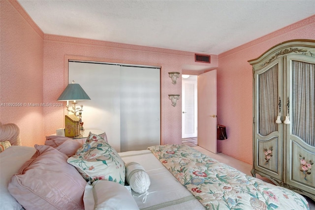 bedroom featuring a textured ceiling, crown molding, and a closet