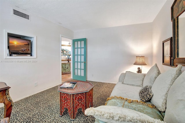 living room with a textured ceiling and carpet floors