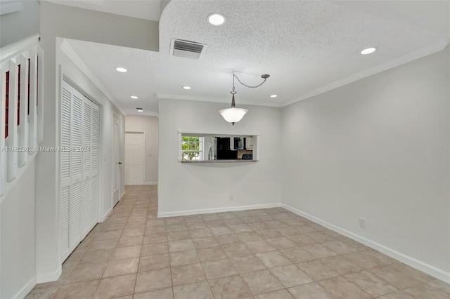 interior space with a textured ceiling and crown molding