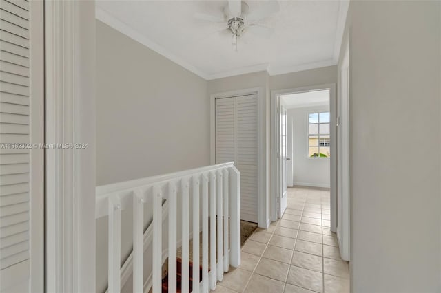 hallway with crown molding and light tile patterned floors